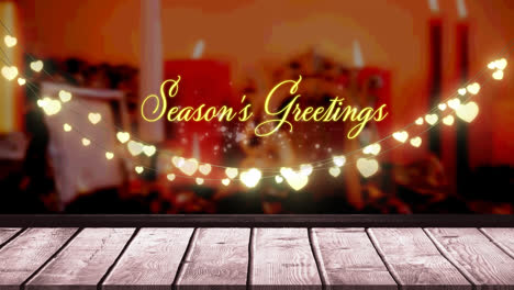 Seasons-greetings-text-and-glowing-yellow-heart-shaped-fairy-light-decoration-over-wooden-plank