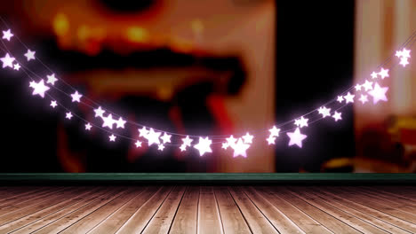 Glowing-pink-star-shaped-fairy-light-decoration-hanging-over-wooden-plank