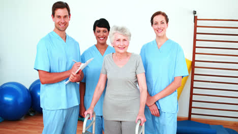 Elderly-woman-smiling-with-her-physical-rehab-team