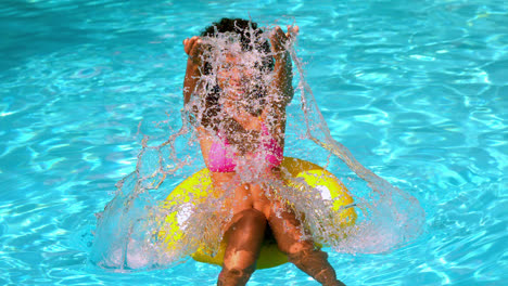 Happy-woman-in-pink-bikini-having-fun-in-inflatable-ring-in-pool