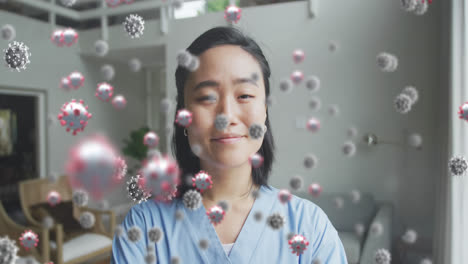 Animation-Von-Covid-19-Zellen-über-Einer-Lächelnden-Asiatischen-Ärztin