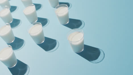 Video-of-row-of-glasses-of-milk-on-blue-background