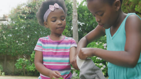 Happy-african-american-girls-wearing-gloves-and-working-in-garden