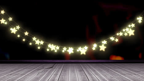 Glowing-yellow-star-shaped-fairy-light-decoration-hanging-over-wooden-plank