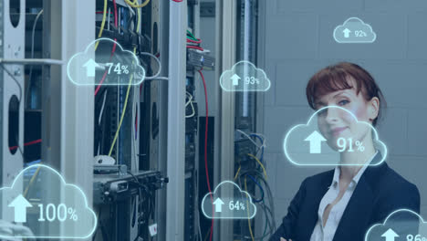 Animation-of-cloud-icons-with-growing-numbers-over-caucasian-woman-in-server-room