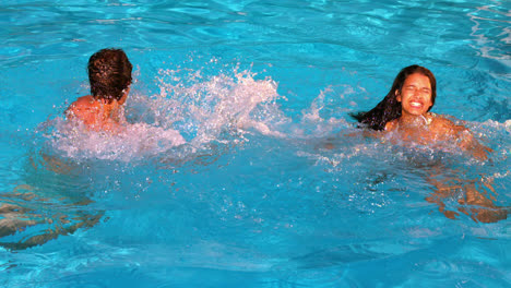 Couple-splashing-and-having-fun-in-swimming-pool