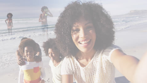 Composite-of-happy-african-american-family-taking-selfie,-and-running-on-beach