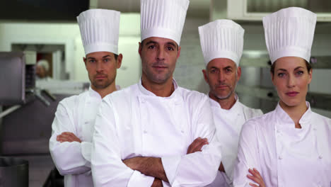 Four-serious-chefs-looking-at-camera-with-arms-crossed
