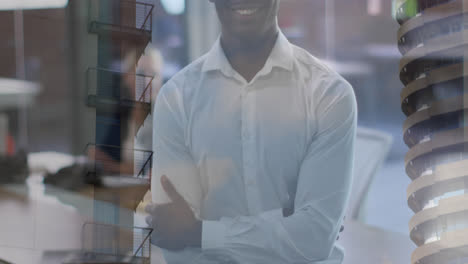 Composite-of-portrait-of-happy-african-american-man-in-office,-and-city-buildings