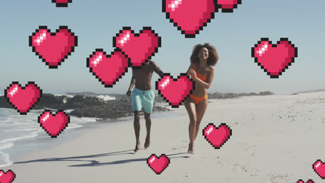 Animation-of-hearts-floating-over-happy-african-american-couple-running-on-beach