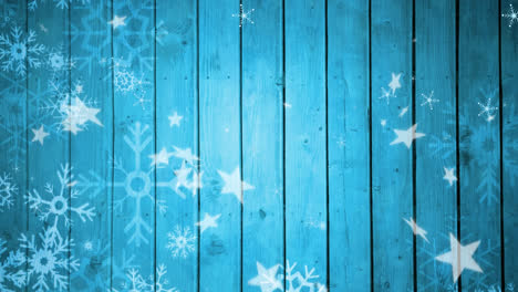 Animation-of-falling-snowflakes-and-stars-on-blue-wooden-background