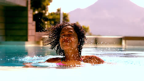 Woman-shaking-her-wet-hair-in-swimming-pool