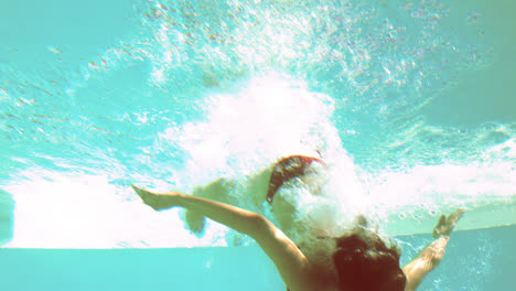 Brunette-diving-underwater-in-swimming-pool