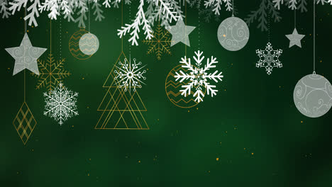 Snow-falling-over-christmas-decorations-hanging-against-spots-of-light-on-green-background