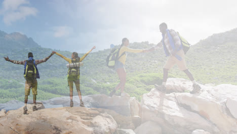 Composite-of-happy-african-american-couple-hiking-on-rocks,-and-raising-hands-looking-at-the-view
