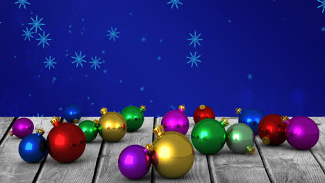 Animation-Von-Weihnachtskugeln-über-Schneeflocken-Auf-Blauem-Hintergrund