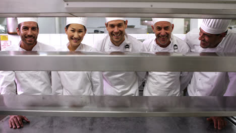 Smiling-chefs-standing-in-a-row-at-the-order-station