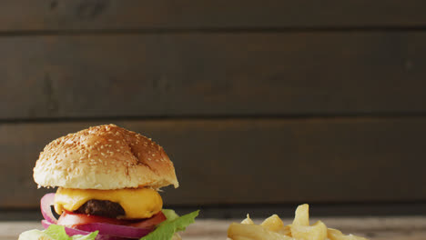 Video-of-cheeseburger-and-chips-against-rustic-wooden-background-with-copy-space