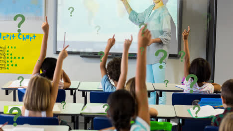Animation-of-green-question-marks-over-elementary-school-pupils-raising-hands-in-class