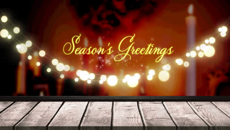 Seasons-greetings-text-and-glowing-yellow-fairy-light-decoration-hanging-over-wooden-plank