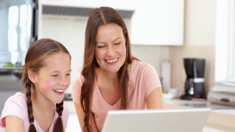 Mother-using-the-laptop-with-her-daughter