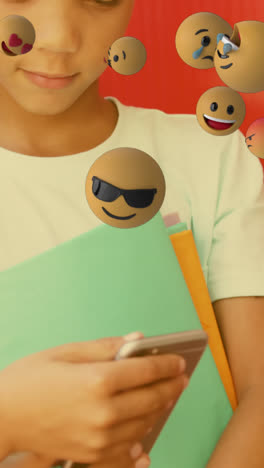 Animation-of-emojis-icons-over-diverse-schoolboys-using-smartphone
