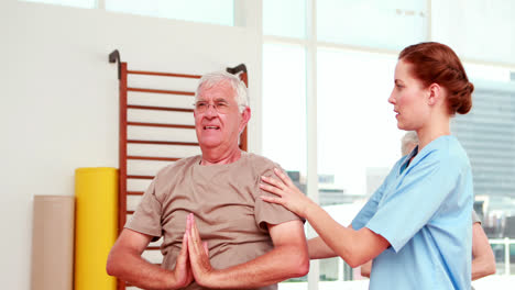 Injured-senior-citizen-exercising-with-physiotherapist