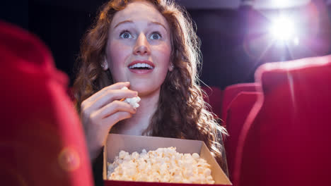 Animation-of-caucasian-woman-eating-popcorn-in-cinema
