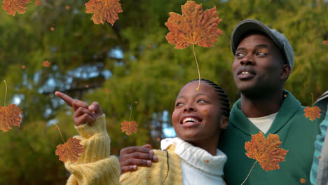 Animation-of-autumn-leaves-falling-over-african-american-parents-with-son-in-park