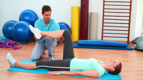 Trainer-helping-his-client-bend-her-knee