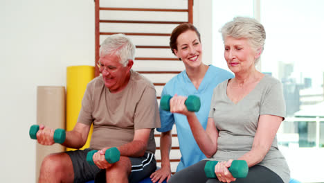 Happy-senior-citizens-exercising-with-physiotherapist