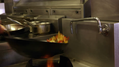 Chef-tossing-vegetables-in-a-wok-over-a-large-flame