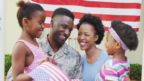 Afroamerikanischer-Soldat-Umarmt-Seine-Lächelnde-Familie-über-Der-Amerikanischen-Flagge