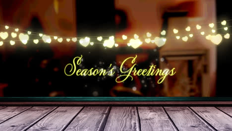 Animation-of-fairy-lights-and-seasons-greetings-text-over-wooden-boards