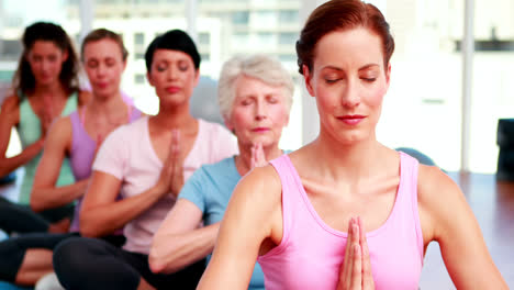 Group-of-peaceful-women-in-fitness-studio-doing-yoga