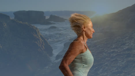 Composite-of-senior-caucasian-woman-running,-with-sunset-over-cliffs-and-sea