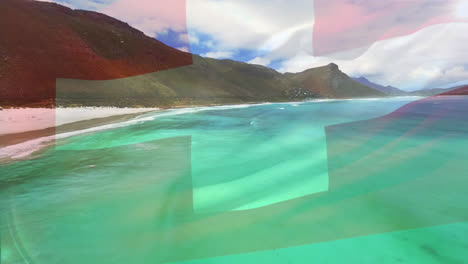 Digital-composition-of-waving-switzerland-flag-against-aerial-view-of-the-beach