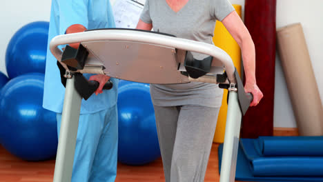 Physical-therapist-showing-patient-how-to-use-treadmill