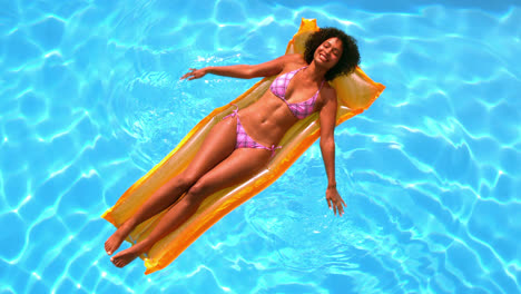 Glückliche-Frau-Entspannt-Sich-Auf-Luftmatratze-Im-Schwimmbad