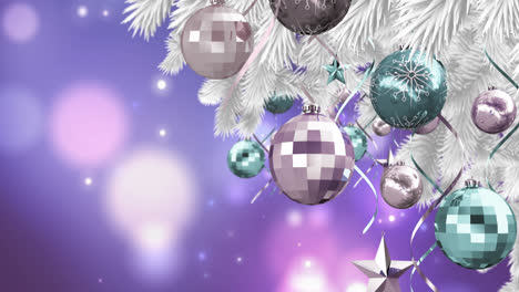 Christmas-decorations-hanging-on-christmas-tree-against-spots-of-light-on-purple-background