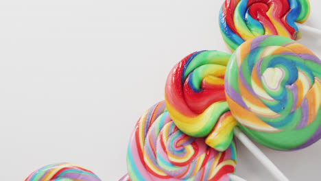 Video-of-rows-multicoloured-lollipops-on-white-background