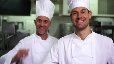 Two-smiling-chefs-giving-ok-sign-to-camera