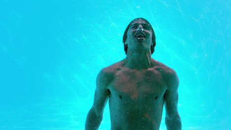 Happy-man-posing-underwater-in-swimming-pool