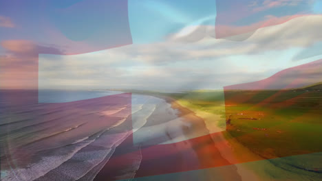 Digital-composition-of-waving-switzerland-flag-against-aerial-view-of-the-beach