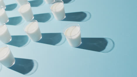 Video-of-row-of-glasses-of-milk-on-blue-background