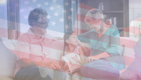 Animation-Der-Flagge-Der-USA-über-Glücklichen-Kaukasischen-Großeltern-Und-Enkelin,-Die-Auf-Dem-Sofa-Sitzen