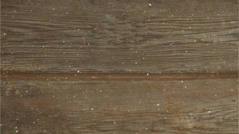 Digital-composition-of-snow-falling-over-textured-wooden-surface