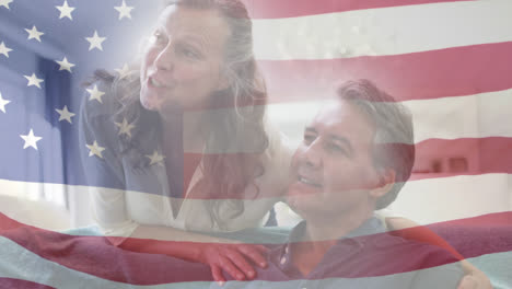 Animation-of-american-flag-blowing-over-smiling-senior-couple-talking-and-embracing