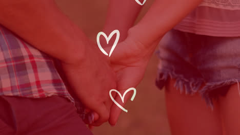 Animation-of-white-hearts-over-caucasian-couple-holding-hands