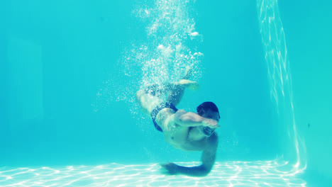 Hombre-Guapo-Nadando-Hacia-La-Cámara-Bajo-El-Agua